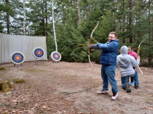 picture of teenaged boy with a bow and arrow, learning archery